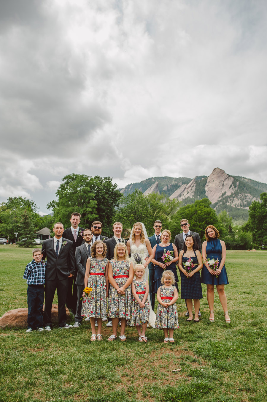 full wedding party poses in front of boulder foothills at chautauqua