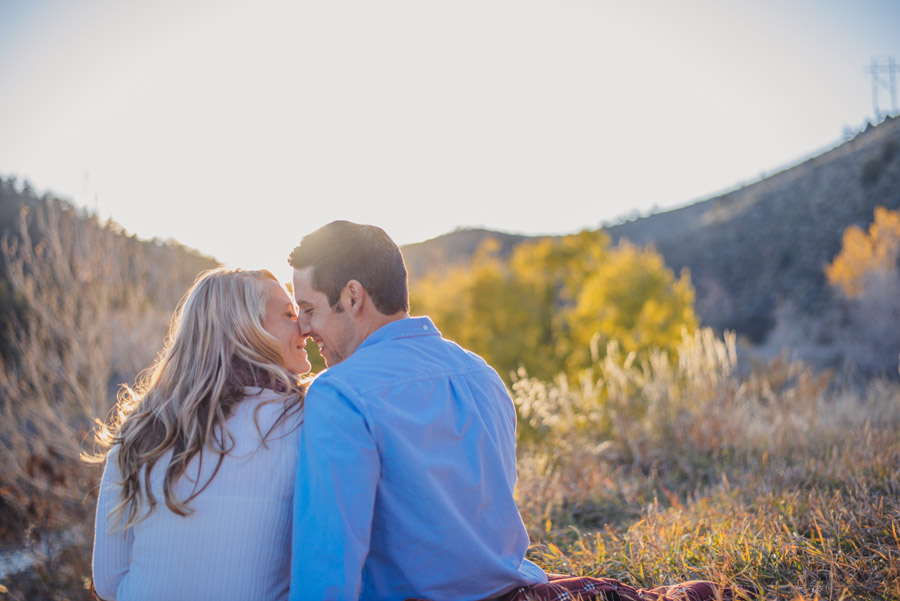 couple kiss watching sun set in the mountains of evergreen, colorado