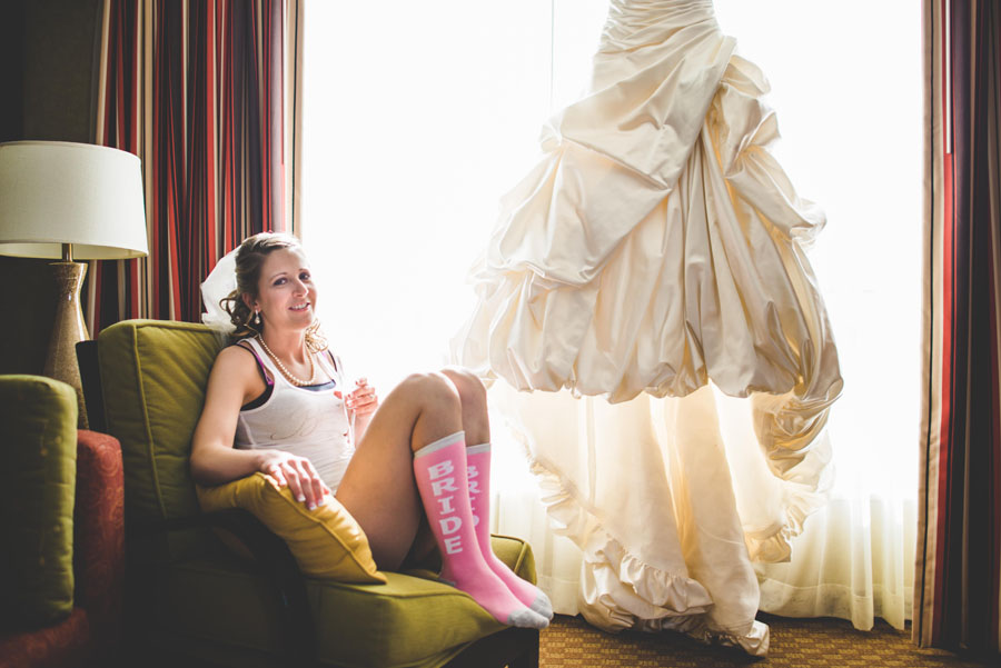 bride relaxing next to her dress before wedding at the Curtis Ballroom