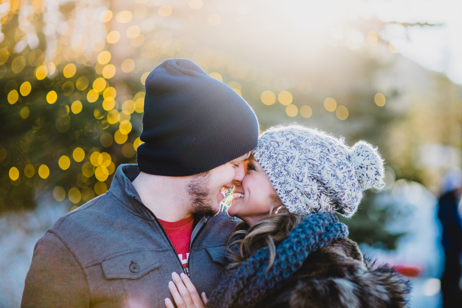 couple kissing with christmas lights in the background