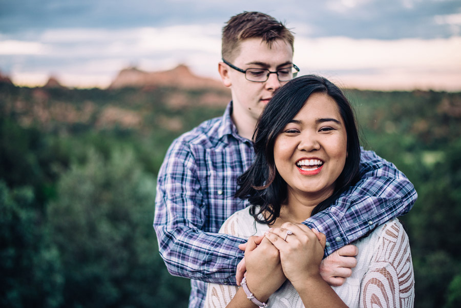 Laughing couple pose for engagement photos in Garden of the Gods